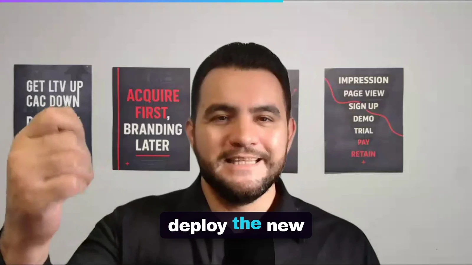 Version one frame: the speaker in front of three posters with a single caption, no cutaway